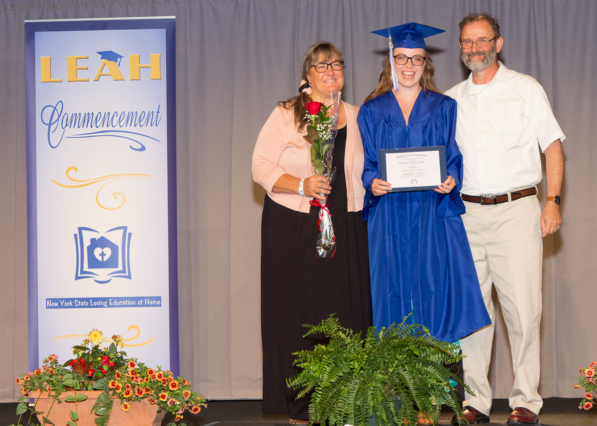 Stage photo of graduating senior and parents