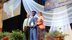 Parents and Graduate on stage at LEAH Commencement.